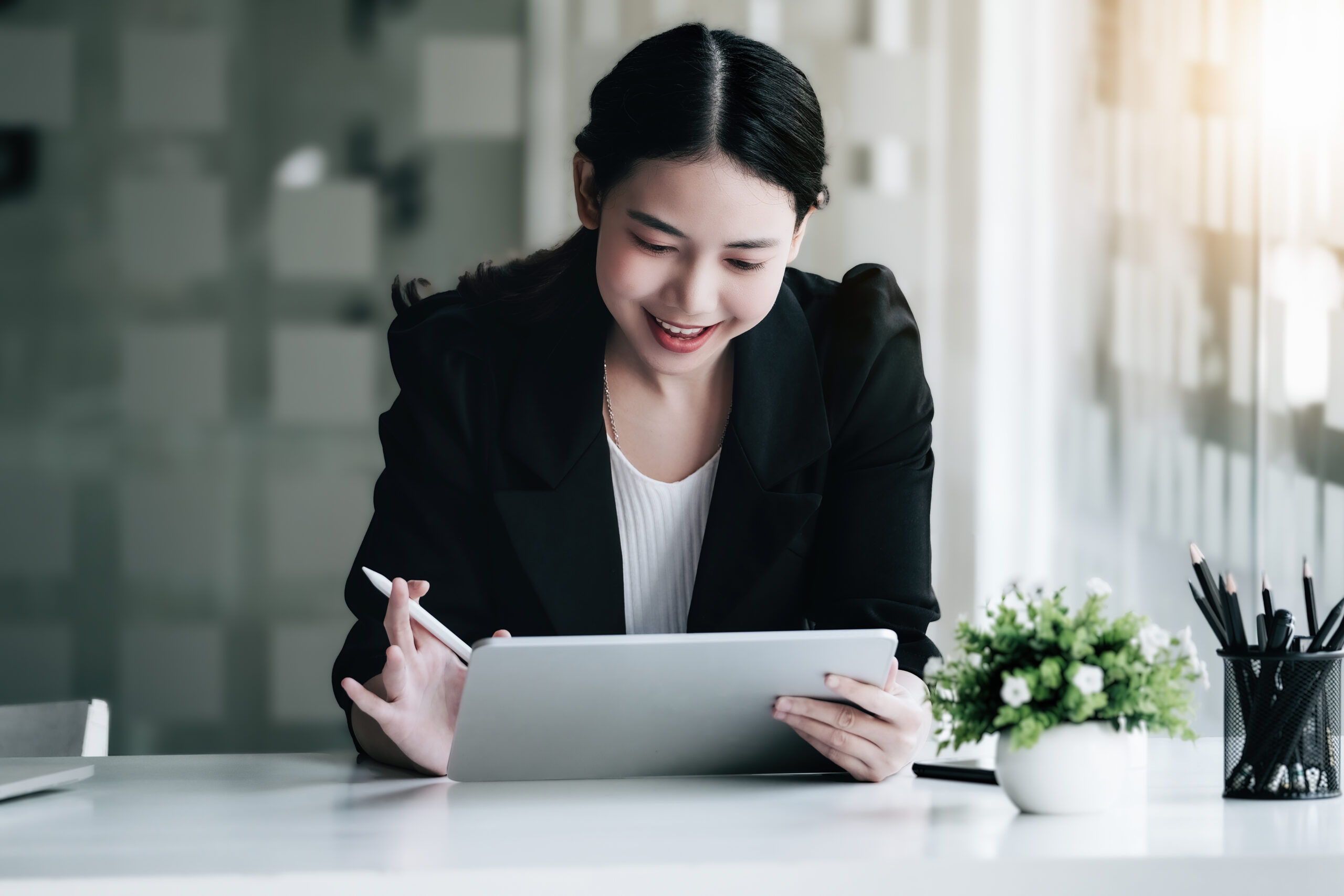 Jeune femme asiatique tenant dans un bureau tenant une tablette.