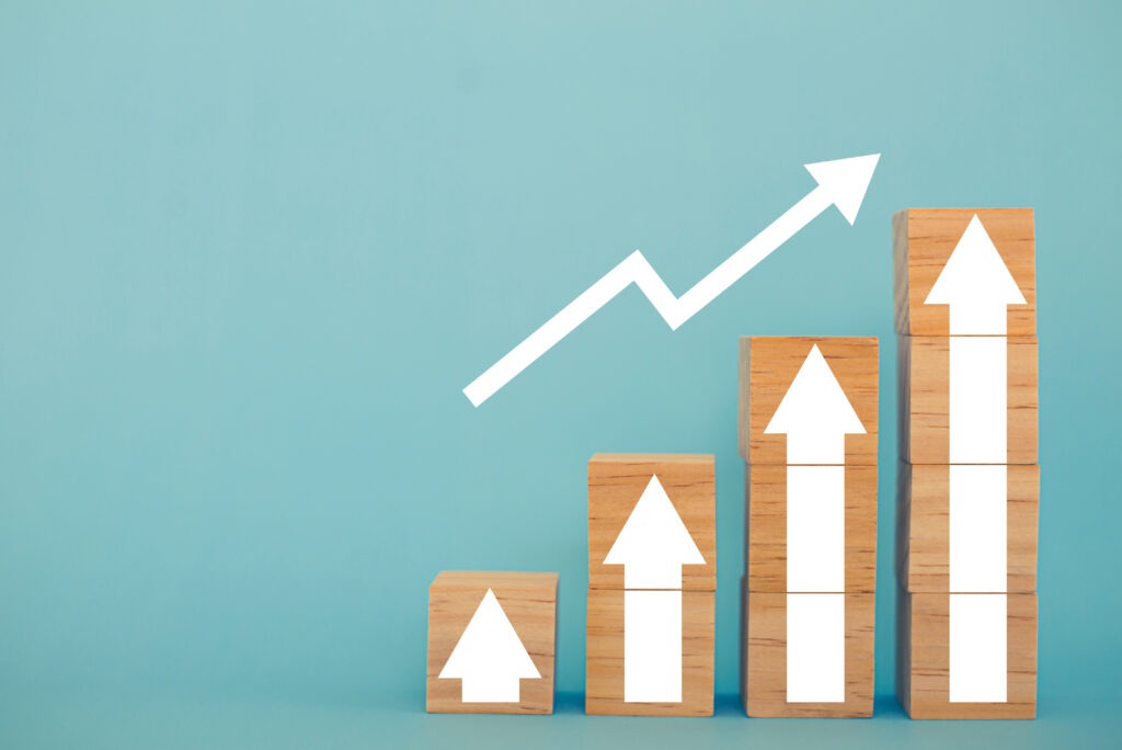 Signes et symboles de bloc en bois avec flèche vers le haut taux d'intérêt de croissance financière et commerciale et taux d'intérêt hypothécaires sur le concept d'inflation des investissements sur fond bleu.